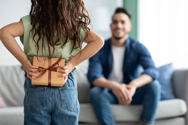 A happy family playing outdoor games and laughing together, celebrating with fun Father's Day Activities ideas like backyard challenges, grilling, and card games.